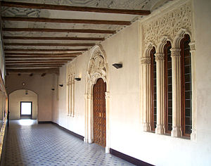 Corredor de acceso a las salas nobles del Palacio de los Reyes Católicos. A la derecha, portada de la entrada principal.